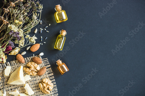 Cosmetic and medical oil of walnut and almonds on a black background