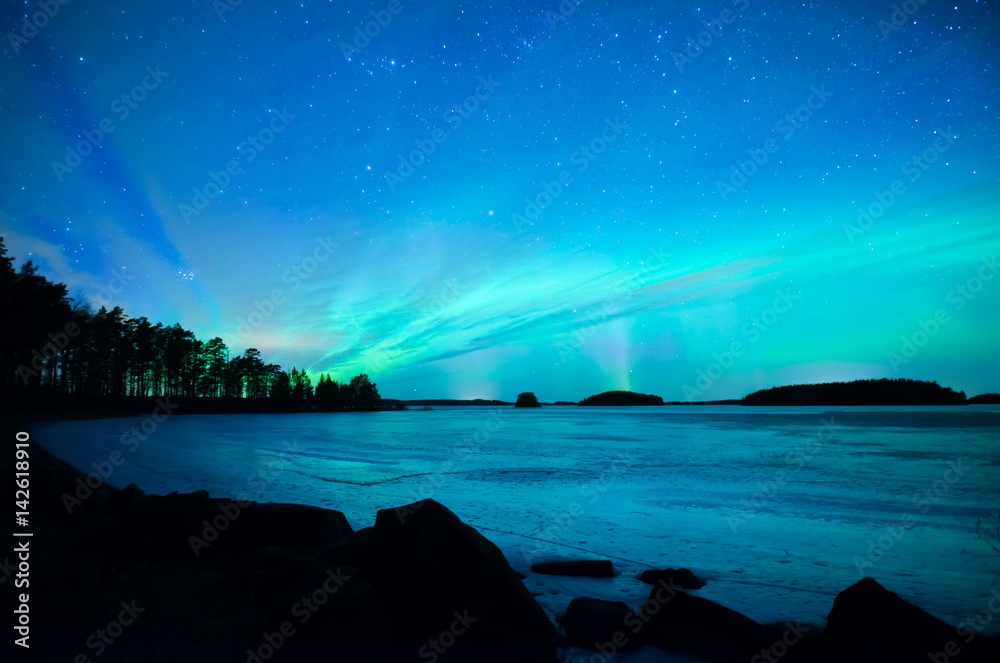 Northern lights dancing over frozen lake in spring