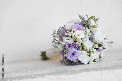 Bouquet bianco e lilla sopra un muretto bianco