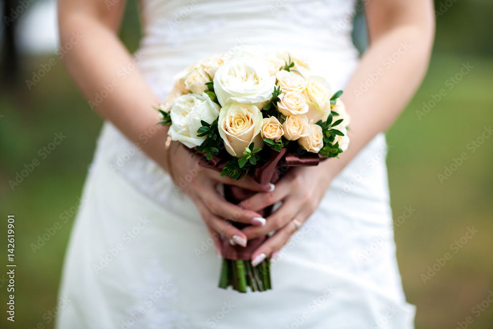 Beauty wedding bouquet in bride's hands, close - up Beauty wedding bouquet in bride's hands, close - up