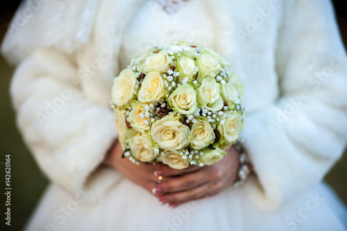 Beauty wedding bouquet in bride's hands, close - up photo