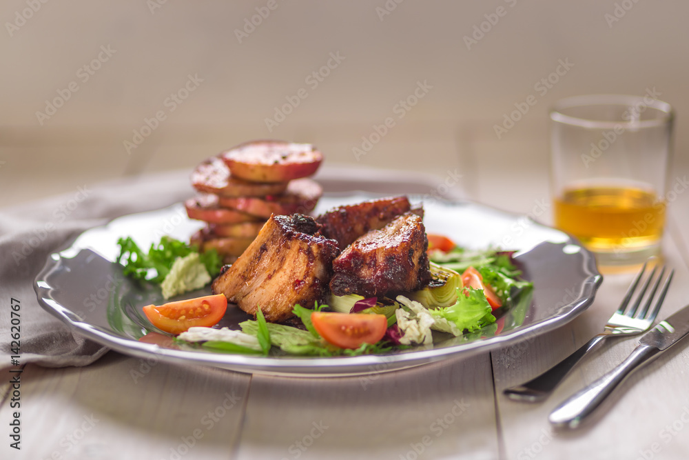 Hot Meat Dishes. Pork ribs grilled with salad and apples on a plate.