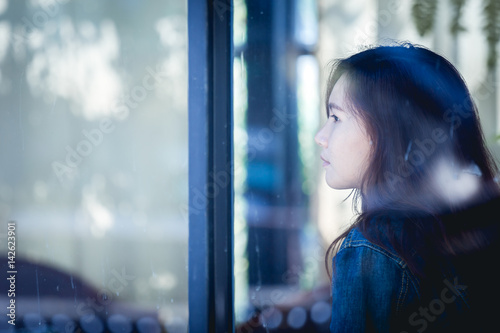 Asia teenage hipster in thinking alone at cafe. Backside woman in sitting. © PPstock