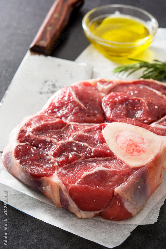 Raw meat and ingredients on black slate 
