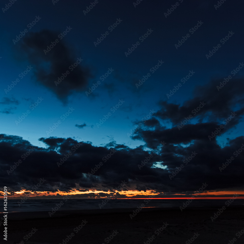 Dark blue cloudy sky over the Baltic sea at night