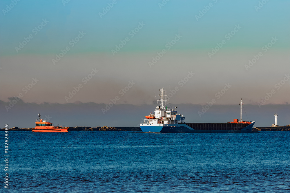 Blue cargo ship leaving Riga and entering Baltic sea