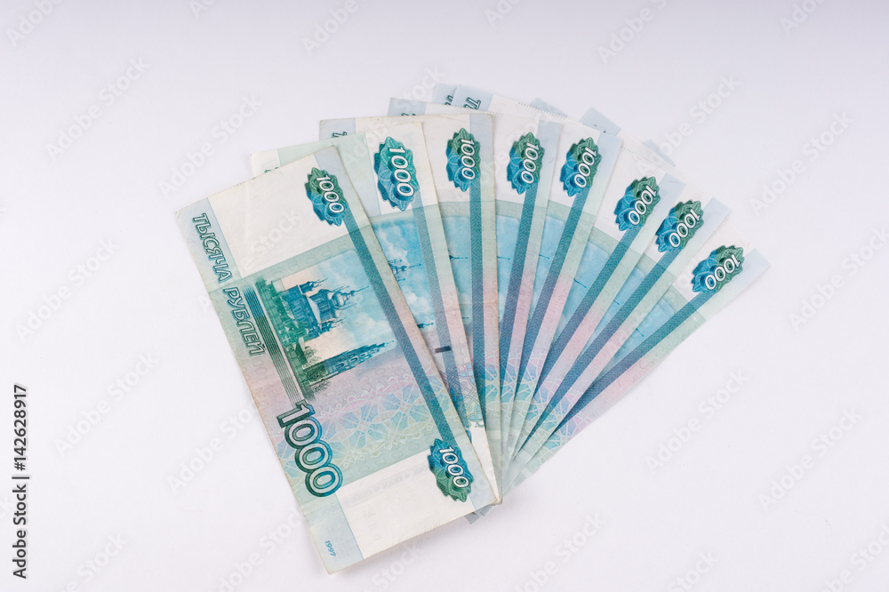 A stack of thousand-ruble banknotes, spread out money. Russian currency on a white background. A stack of thousand-ruble banknotes, spread out money. Russian currency on a white background.