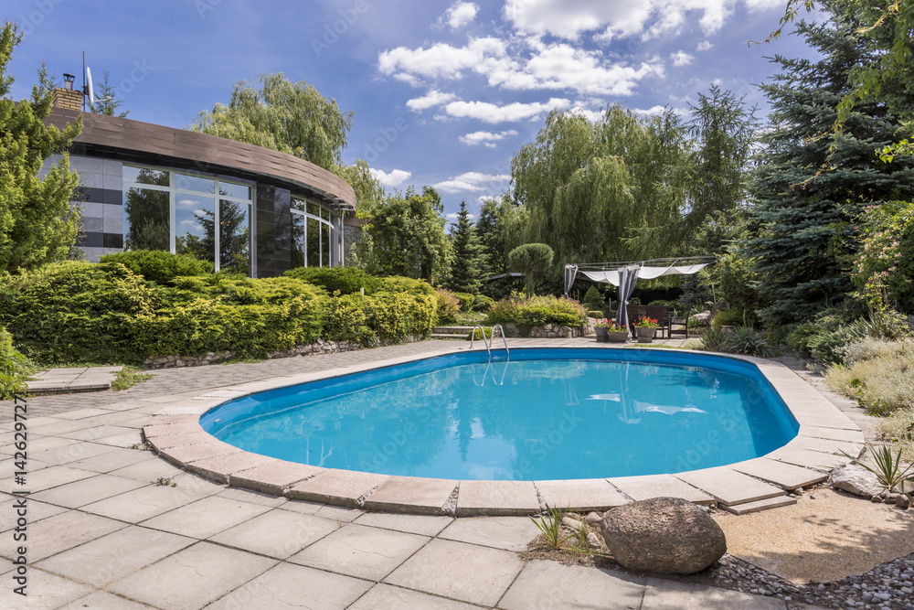 Oval swimming pool in big garden
