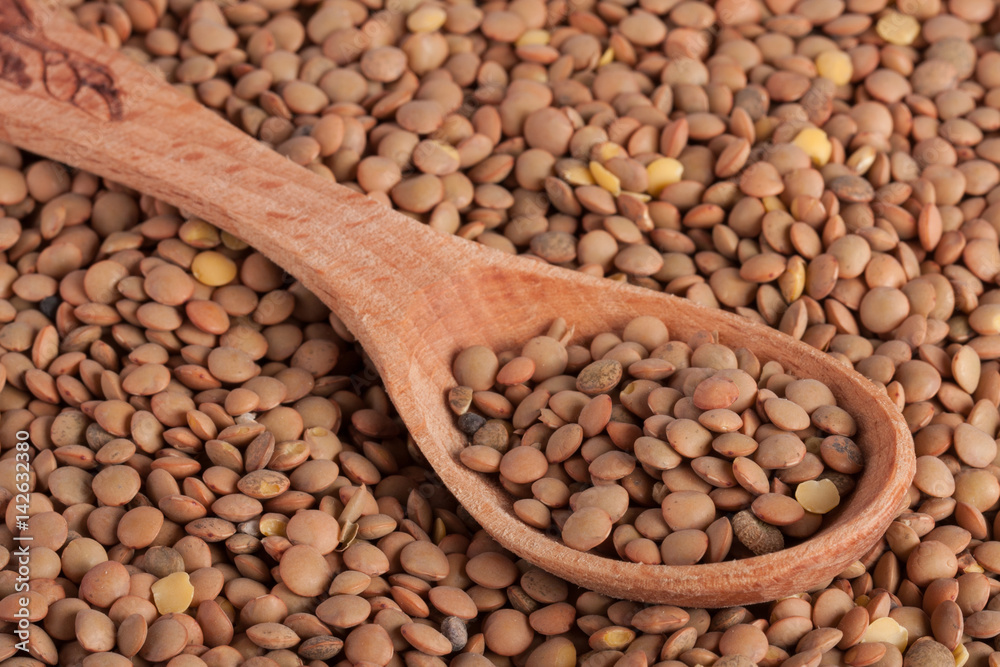 Fototapeta premium Lentils in a wooden spoon as background