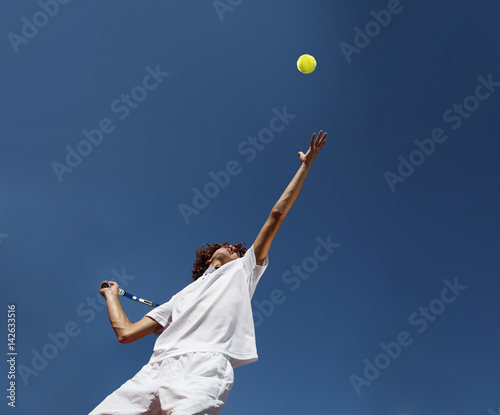 tennis player with racket during a serve in match game photo