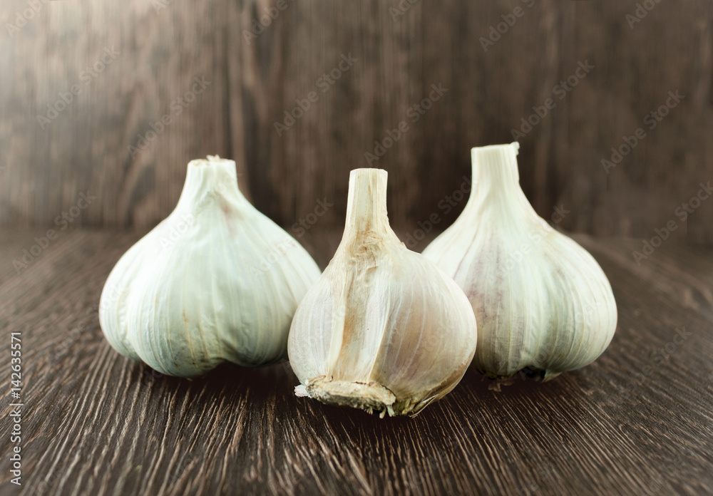 Obraz premium Group bulb Head of garlic on wood background with shadow