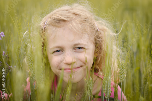 lovely blond girl portrait in green field
