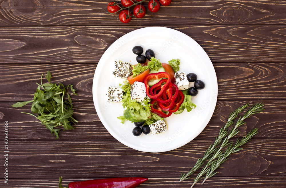 Appetizing greek salad with spices, cucumbers and feta cheese. View from above. Empty space for your text