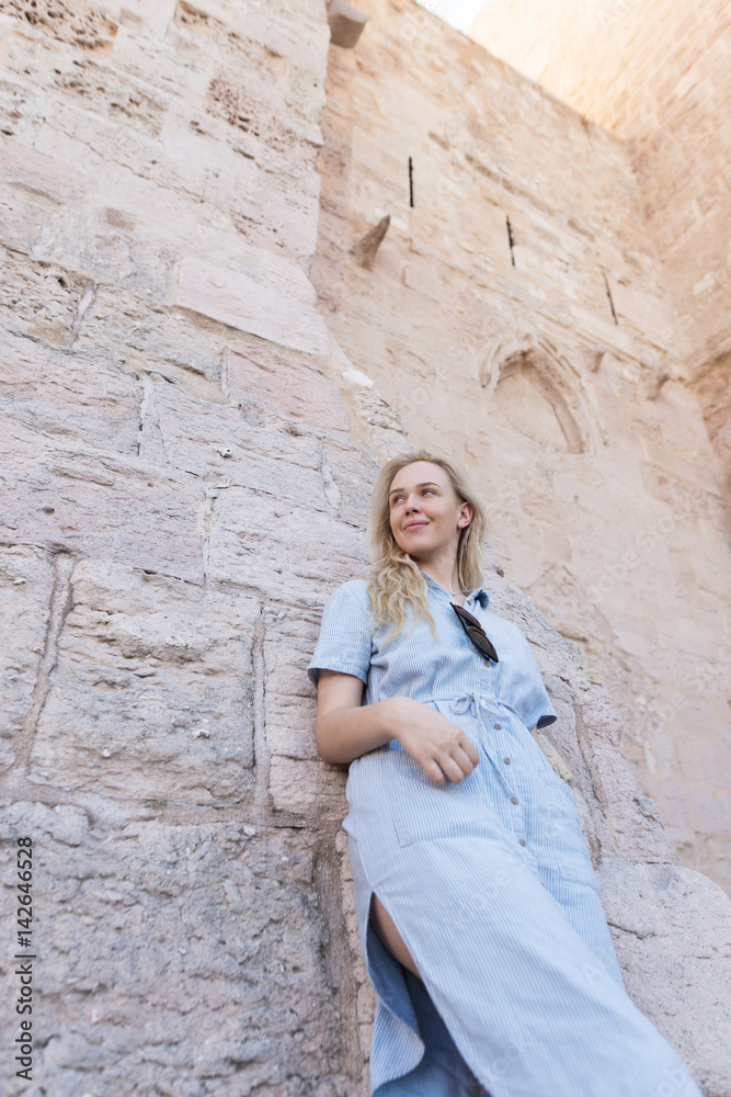 Photo of a beautiful blonde woman against the rustic church wall in France in Marseille