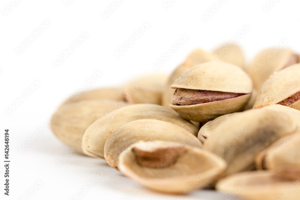 Closeup macro roasted pistachio over white background Closeup macro roasted pistachio over white background