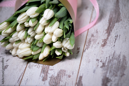 white tulips on white wooden background photo