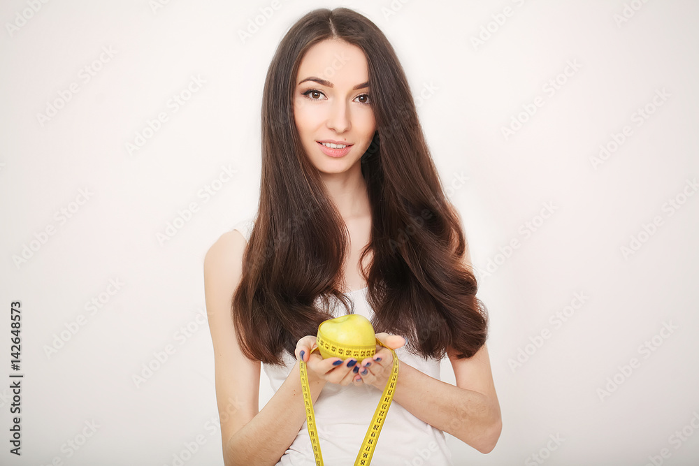 Diet. Slim young woman measuring her waist with a tape measure and having green apple in her hands. Healthy life Diet. Slim young woman measuring her waist with a tape measure and having green apple in her hands. Healthy life