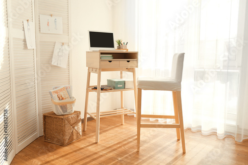 High wooden table as stand up work place in modern interior