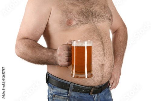 Man with big belly holding glass of beer on white background