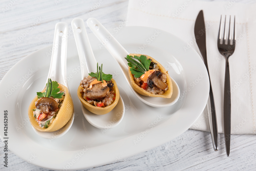 Plate with stuffed pasta on wooden table Plate with stuffed pasta on wooden table