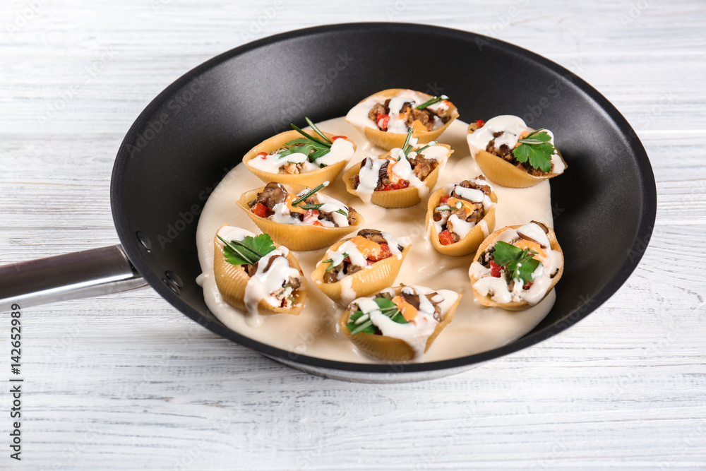 Pan with stuffed pasta on wooden table Pan with stuffed pasta on wooden table