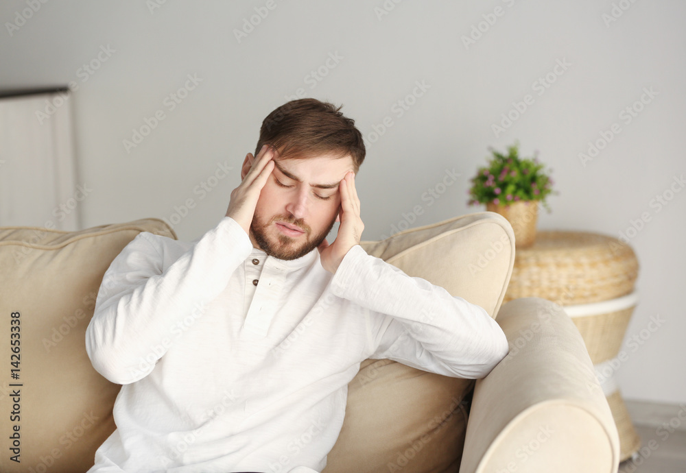 Young man suffering from headache at home Young man suffering from headache at home