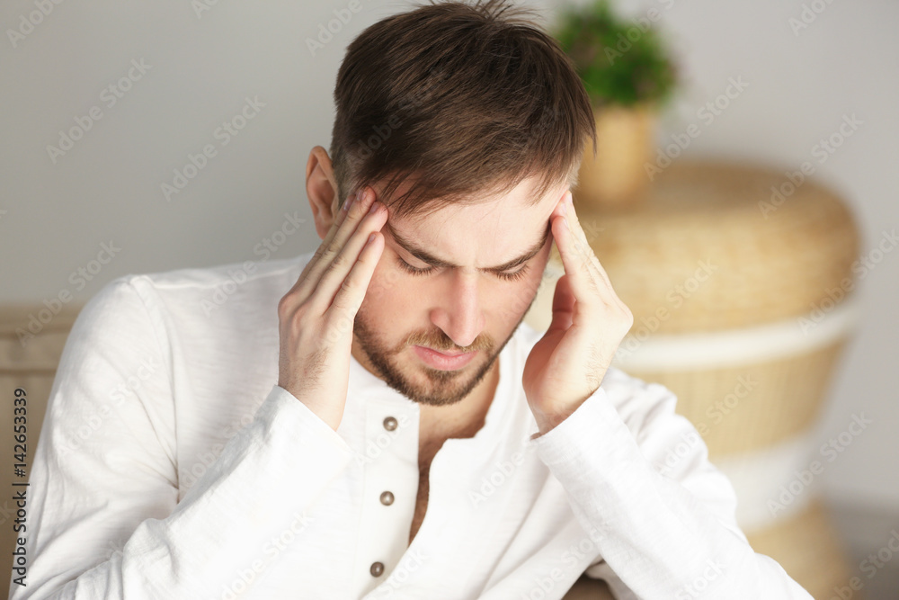 Young man suffering from headache at home Young man suffering from headache at home