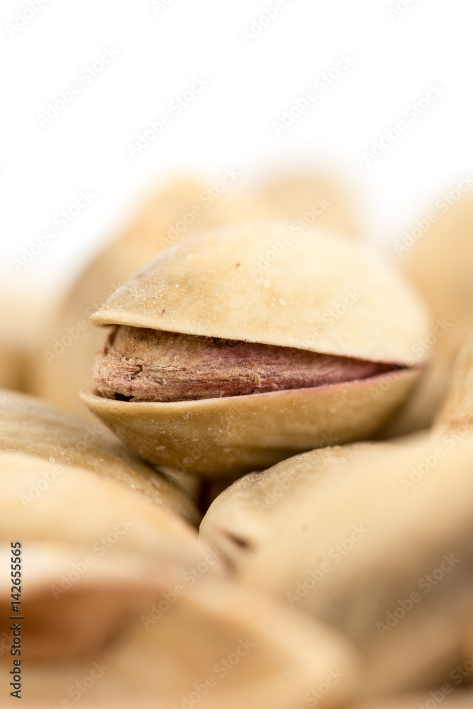 Closeup macro roasted pistachio over white background Closeup macro roasted pistachio over white background