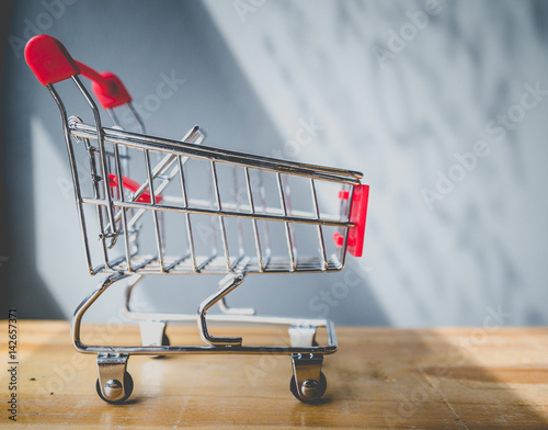 side view of Shopping cart on wood table ,shopping concept