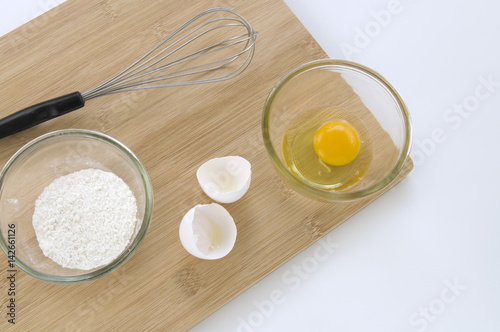 Baking Whisk and Eggs on Wooden Board Viewed from Above