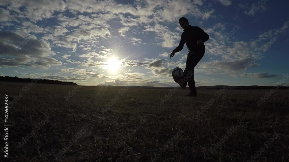 soccer. Man is stuffing a football soccer ball silhouette at sunset football sport freestyle soccer. Man is stuffing a football soccer ball silhouette at sunset football sport freestyle