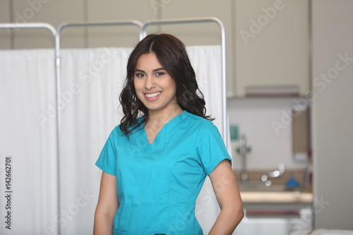 Fototapeta Naklejka Na Ścianę i Meble -  Portrait of a young attractive hispanic healthcare worker. Nurse in medical clinic.