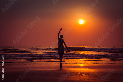 Amazing sunset portrait of the silhouette woman in Arambol beach, North Goa, India