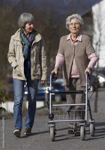 Konstfotografi Seniorin mit Rollator wird von ihrer Tochter begleitet