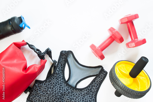 Flat lay of sport equipments with sport bra isolated on white background