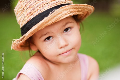 Girl in a straw hat in the park