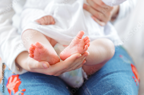 Young mother and newborn baby in white bedroom