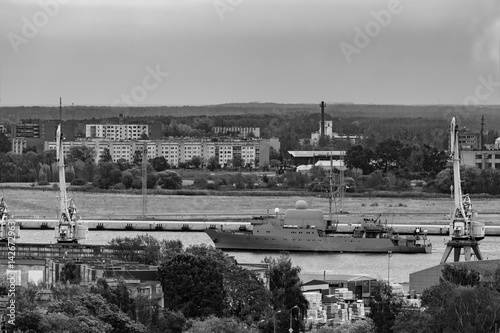 Military ship sailing past the cargo port in Riga, Latvia. Monoc photo