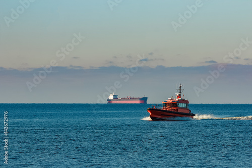Orange pilot ship moving fast from Baltic sea