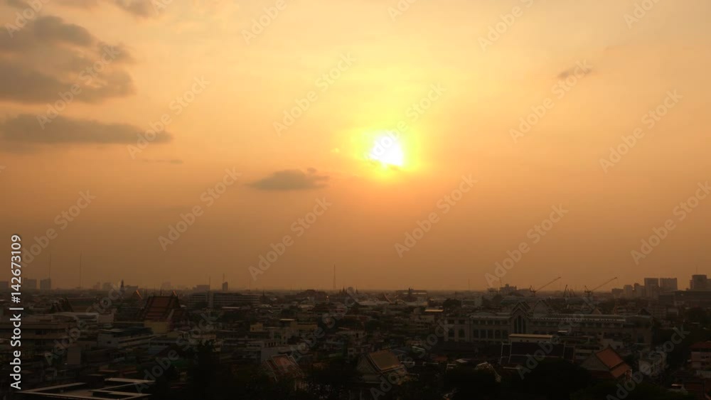A time lapse of the large orange sunset as the massive sun sets into the horizon above the city A time lapse of the large orange sunset as the massive sun sets into the horizon above the city