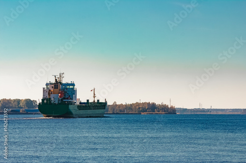 Green cargo ship entering a port of Riga  Europe