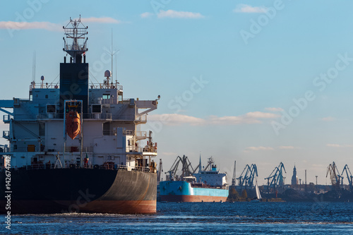 Black cargo ship entering the port of Riga, Europe