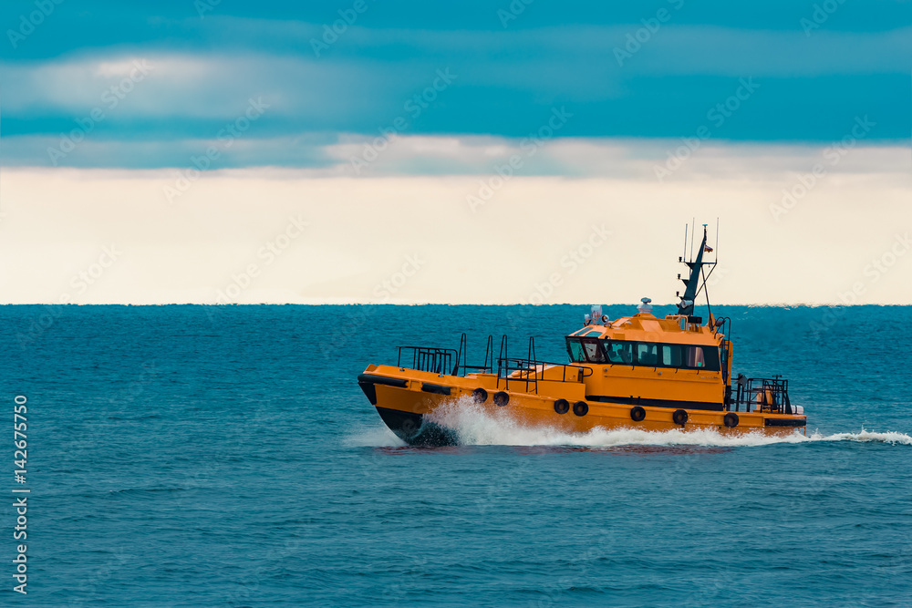 Orange pilot ship moving fast in Baltic sea. Europe
