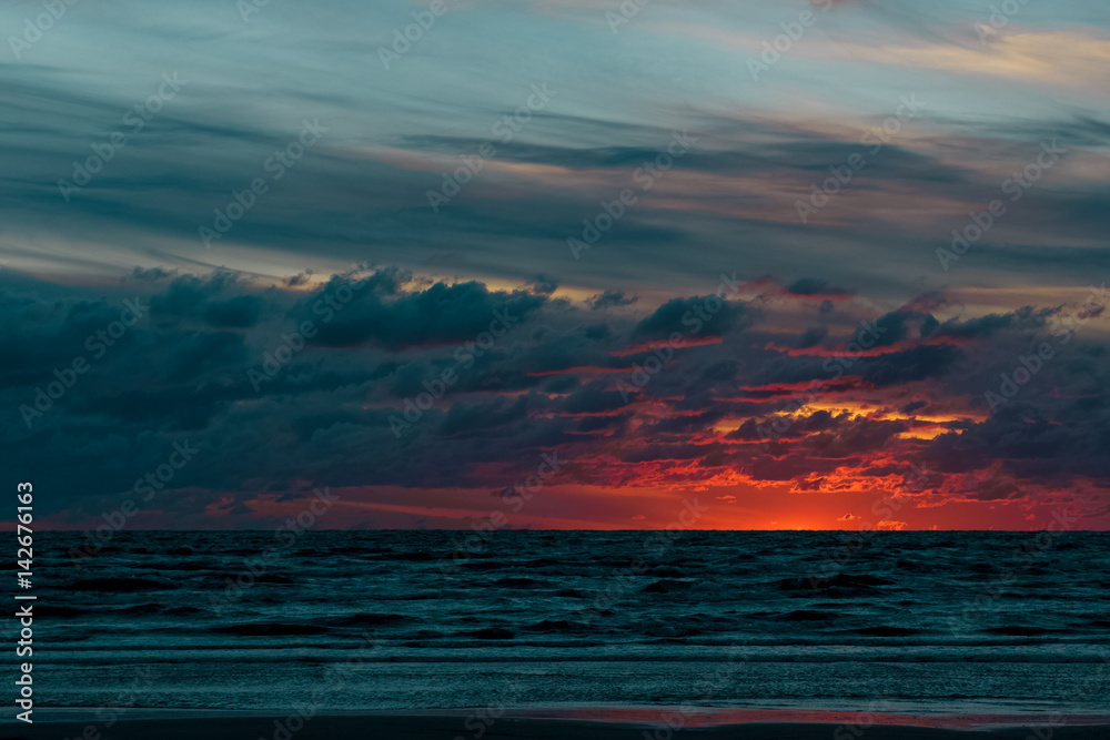 Red cloudy sunset sky over the Baltic sea