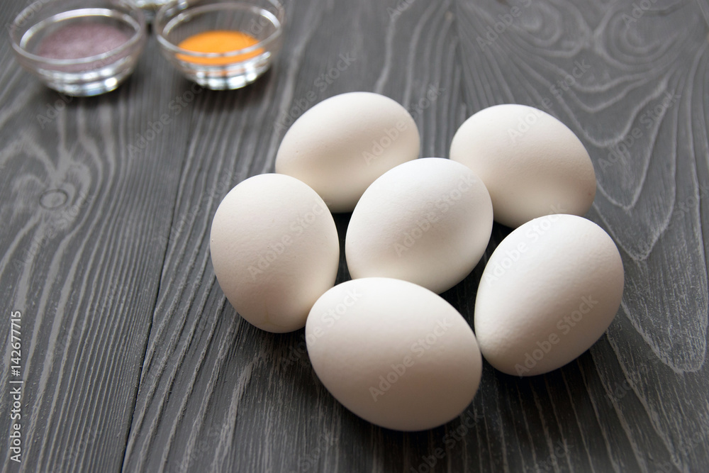 White chicken eggs and color dyes on a gray table. Celebrating Easter White chicken eggs and color dyes on a gray table. Celebrating Easter