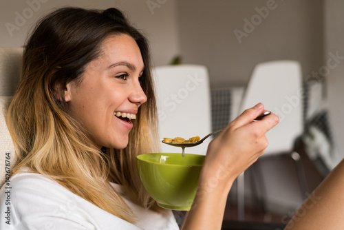Cheerful woman eating cereal photo