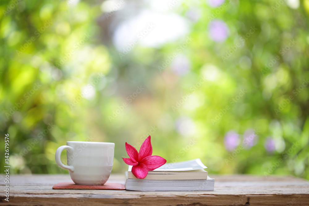 Books with flowers and cup on wooden table Books with flowers and cup on wooden table