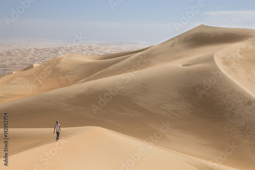 young man walking in the sand dunes of Liwa desert