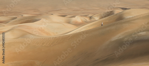young man walking in the sand dunes of Liwa desert