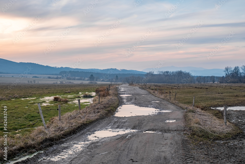 The setting sun over a dirt road The setting sun over a dirt road